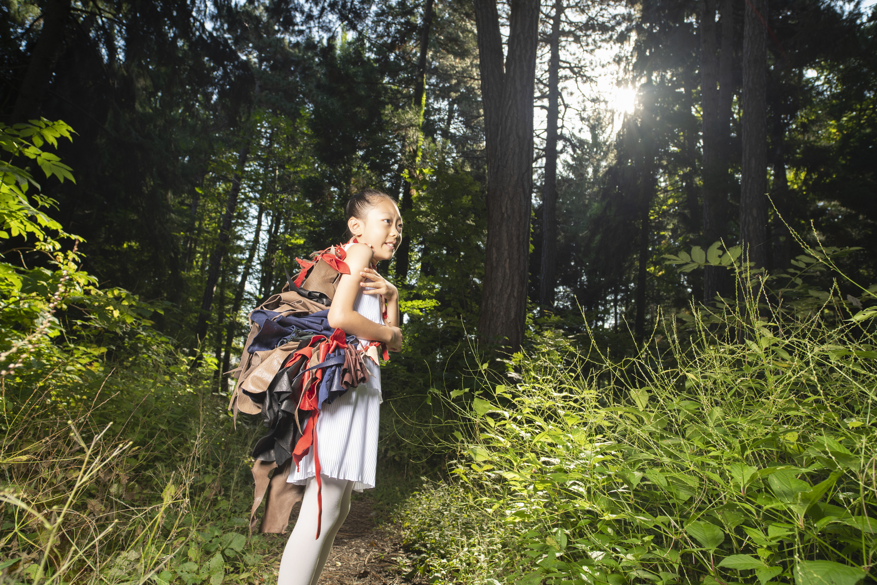 鹿のなめした革をいくつも背負った子供